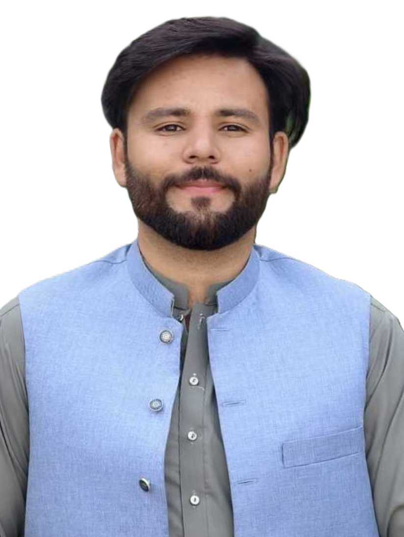 Portrait of a man with a beard and dark hair wearing a light blue Nehru-style vest over a gray-green shirt, outdoors with greenery in the background.